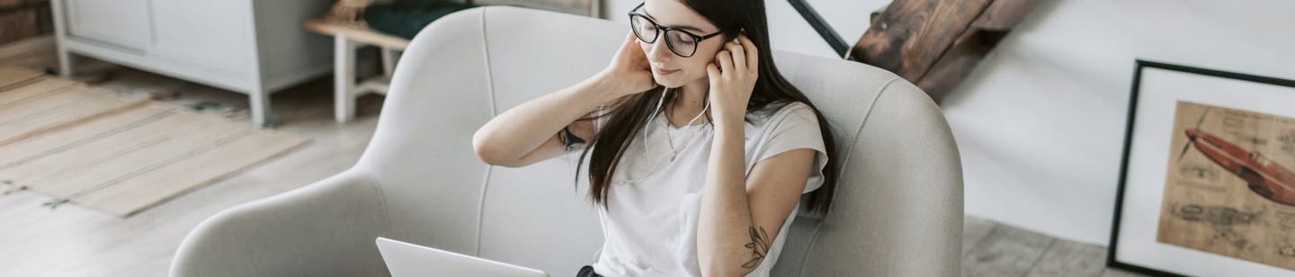 Girl using desktop and headphones in a living room