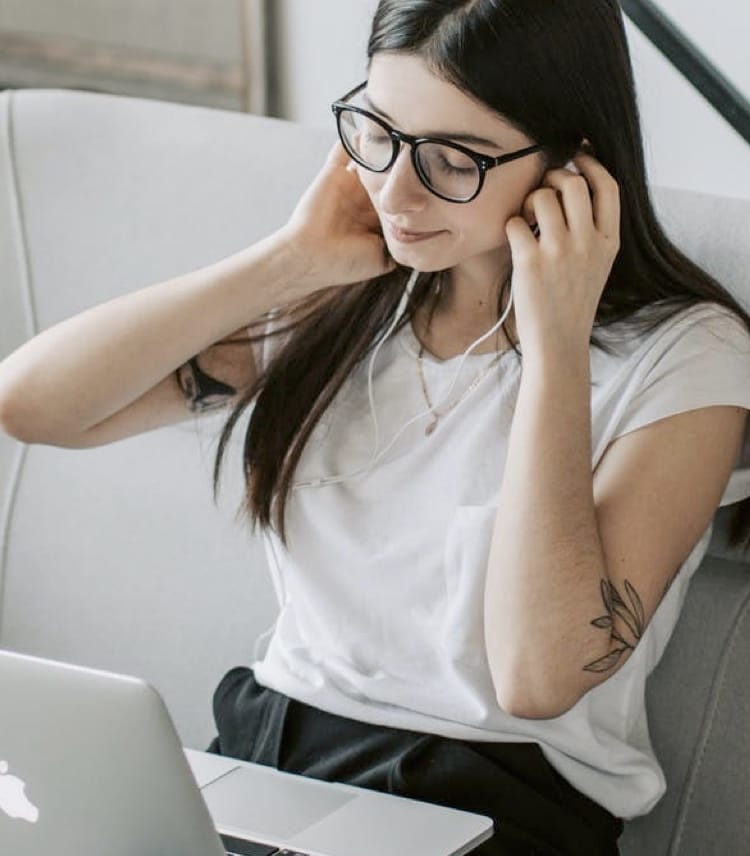 Girl using desktop and headphones in a living room