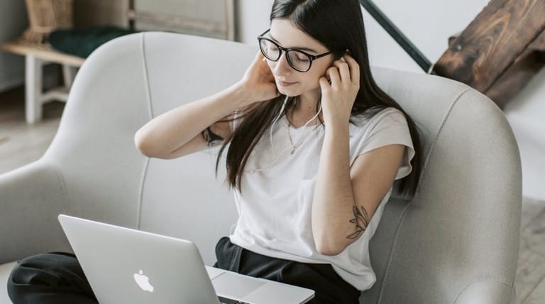 Girl using desktop and headphones in a living room