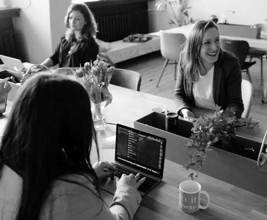 3 women chatting in an office.